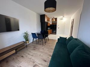 sala de estar con sofá verde y cocina en SDH 3 Radzymin comfortable apartment near Warsaw en Radzymin