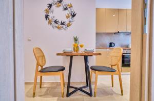 een keuken met een tafel en 2 stoelen bij Sunflower Suites Gouvia Corfu in Gouvia