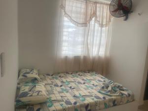 Bett in einem Zimmer mit Fenster und Ventilator in der Unterkunft Américas al límite in Cúcuta