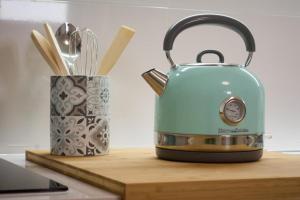 a blue tea kettle sitting on a cutting board at Pópulo Mar in Ponta Delgada