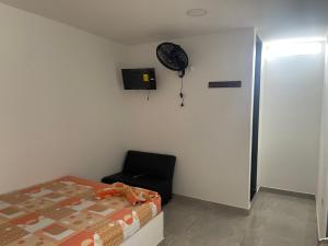 ein Schlafzimmer mit einem Bett und einem Ventilator an der Wand in der Unterkunft Américas al límite in Cúcuta