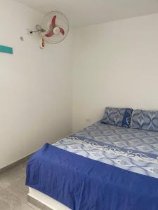 ein Schlafzimmer mit einem Bett und einem Ventilator an der Wand in der Unterkunft Américas al límite in Cúcuta