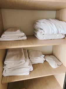 a shelf with folded towels and towels on it at Sunset Apartment in Batumi