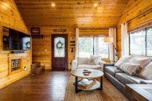 uma sala de estar com um sofá e uma mesa em Luxury cabin, hot tub, slopes, lake & VIEWS! em Fawnskin