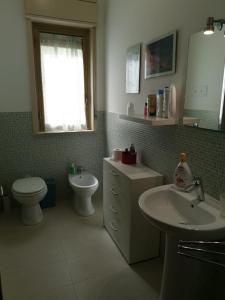 a bathroom with a sink and a toilet and a mirror at Antigone Holiday House in Mondello