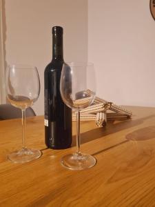 a bottle of wine and two wine glasses on a table at Casa Rosina - Una caramella, nel nucleo, ai piedi della Verzasca- in Gordola
