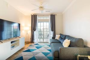 un soggiorno con divano e TV a schermo piatto di Apartment 3 BR in Tuscana Resort , 15" from Disney a Kissimmee