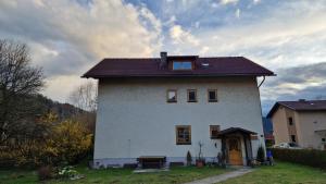 a white house with a brown roof on top of it at Angerpartments-Sonnige große Wohnung mit Balkon und kostenlosen Parkplatz in Döbriach