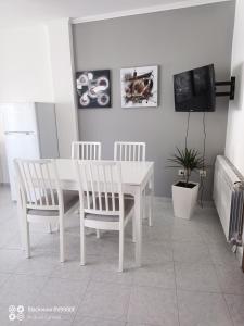 un comedor blanco con una mesa y sillas blancas en Apartamentos Xulia, en Raxó