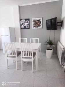 a white dining room with a white table and chairs at Apartamentos Xulia in Raxó
