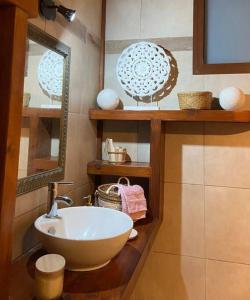 ein Badezimmer mit einem weißen Waschbecken und einem Spiegel in der Unterkunft Bungalow L’Eden in Les Abymes