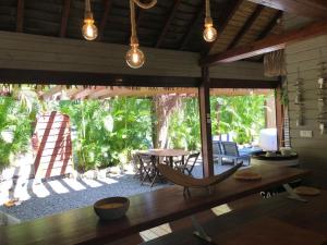 een kamer met een tafel en stoelen en een groot raam bij Bungalow L’Eden in Les Abymes