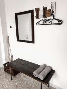 a mirror on a wall next to a bench with towels at Salecce B&B in Lecce