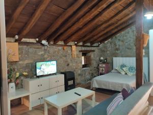 a bedroom with a bed and a tv in a room at Loma Bonita in Valdició