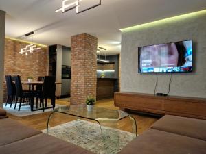 a living room with a tv and a dining room at SkopjeLUX Apartments in Skopje