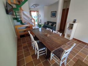 ein Esszimmer mit einem Holztisch und Stühlen in der Unterkunft La Buganvilla in Sirolo