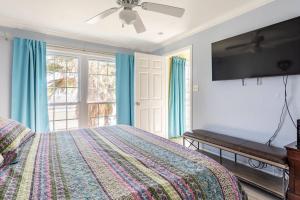 a bedroom with a bed and a flat screen tv at Oceanfront at The Dawns in Galveston