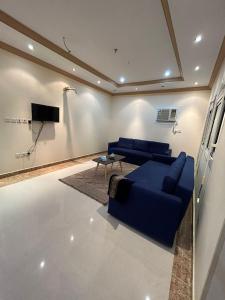 a living room with a blue couch and a tv at شقة راقية Moh in Makkah