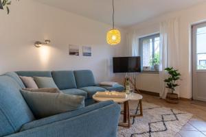 a living room with a blue couch and a table at Koje 34 in Sankt Peter-Ording