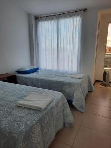 a hotel room with two beds and a window at Loma Blanca in Libertador General San Martín
