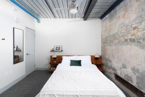 een slaapkamer met een bed en een bakstenen muur bij Flexhome Brewery District 2BR Apt M3 - READ INFO in Milwaukee