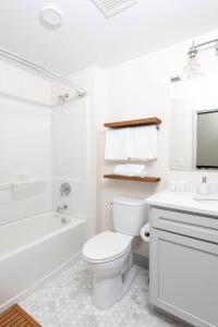 een witte badkamer met een toilet, een bad en een wastafel bij Flexhome Brewery District 2BR Apt M3 - READ INFO in Milwaukee