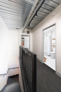 a room with a hallway with a toilet and a balcony at Brewery District 2-Story 2BR Apt Near Fiserv with Rooftop, Gym, and Parking in Milwaukee