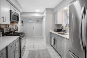 a kitchen with white cabinets and a sink and a refrigerator at Chicago Charm in Chicago +17 photos