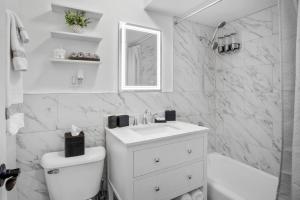 a white bathroom with a sink and a toilet at Chicago Charm in Chicago