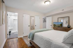 a white bedroom with a bed and a bathroom at Chicago Charm in Chicago