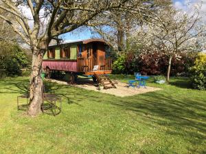 a house in a yard with a tree at ROULOTTE CAPUCINE in Ablon
