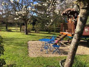 een speeltuin met een picknicktafel en een boom bij ROULOTTE CAPUCINE in Ablon