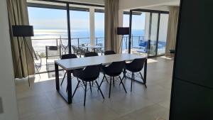uma mesa e cadeiras num quarto com vista para o oceano em Kvarner Luxus Suite am Meer em Lovran