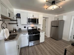 eine Küche mit weißen Schränken und einem Kühlschrank aus Edelstahl in der Unterkunft Flexhome East Side 1BR Apt EN1 - READ INFO in Milwaukee