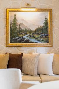 ein Gemälde, das an einer Wand über einer Couch hängt in der Unterkunft Hotel Agelis in Kala Nera