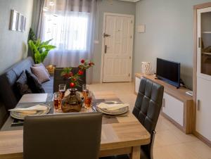 ein Esszimmer und ein Wohnzimmer mit einem Tisch und Stühlen in der Unterkunft Casa La Florida - Holiday Rental in Alicante