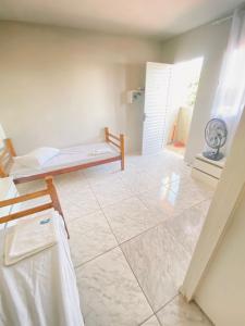a room with a bed and a tiled floor at Pousada Quartos vcp in Viracopos