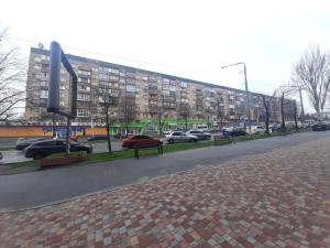 een straat met auto's geparkeerd voor een groot gebouw bij 3-room Luxury Apartment on Sobornyi Avenue 133, by GrandHome in Zaporozhye