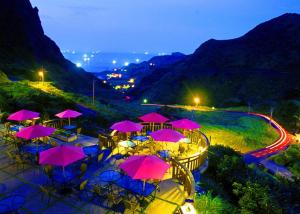 a group of tables with pink umbrellas at night at Formosa Arcadian Villa in Jiufen