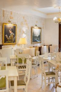 un restaurant avec des tables et des chaises blanches et un canapé dans l'établissement Hotel Agelis, à Kala Nera