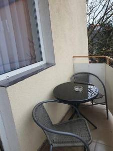 锡比乌Apartament Mirela的阳台上有一张桌子和两把椅子