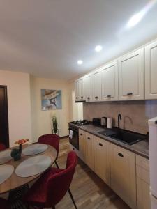 锡比乌Apartament Mirela的带桌子和椅子的厨房