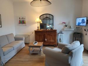 uma sala de estar com dois sofás e uma mesa em Les bords de Rance em Dinan