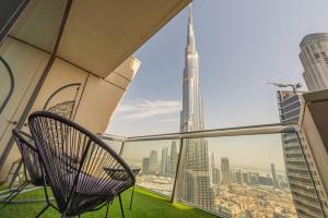 a chair on a balcony with a view of the city at FIRST CLASS 3BR with full BURJ KHALIFA and FOUNTAIN VIEW in Dubai