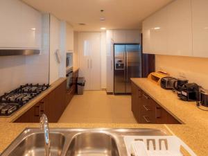 a kitchen with a sink and a stove top oven at FIRST CLASS 3BR with full BURJ KHALIFA and FOUNTAIN VIEW in Dubai