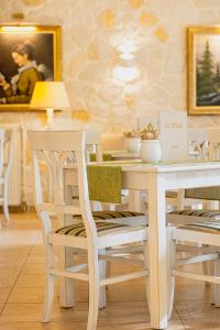 - une table à manger blanche avec des chaises blanches, une table et des chaises dans l'établissement Hotel Agelis, à Kala Nera