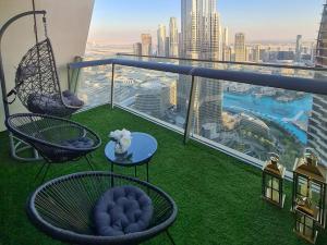 a balcony with chairs and tables and a view of a city at FIRST CLASS 3BR with full BURJ KHALIFA and FOUNTAIN VIEW in Dubai