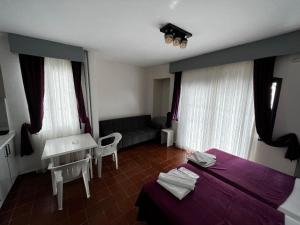 een slaapkamer met een paars bed en een bank bij Andy's Apart Hotel in Marmaris