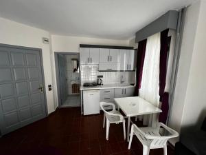 een kleine keuken met een tafel en stoelen in een kamer bij Andy's Apart Hotel in Marmaris