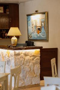 - un salon avec une cheminée en pierre et une lampe dans l'établissement Hotel Agelis, à Kala Nera